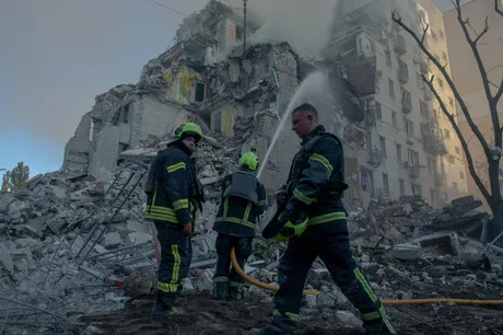 Pompierii intervin la o clădire distrusă în urma unui atac.