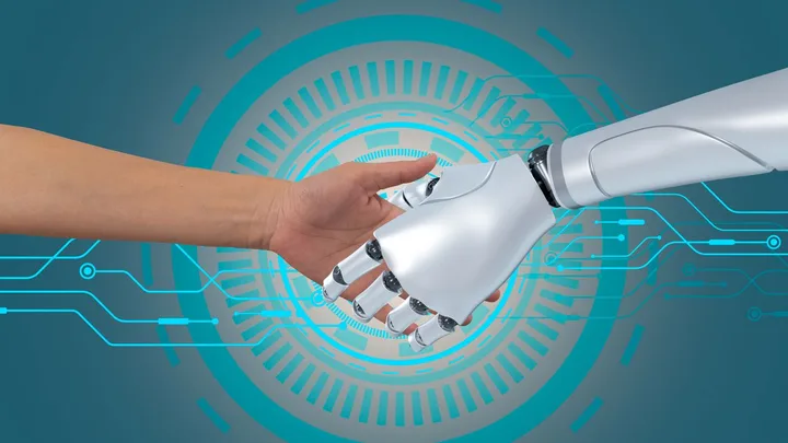 Interacțiune între un robot și o mână umană, simbolizând colaborarea tehnologică.