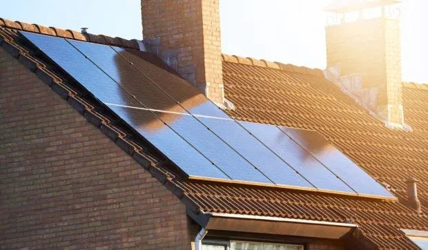 Panouri fotovoltaice instalate pe acoperișul unei clădiri, captând lumina soarelui.
