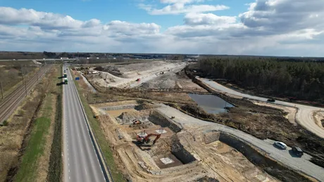 Peisaj de șantier cu drum și lucrări în construcție.