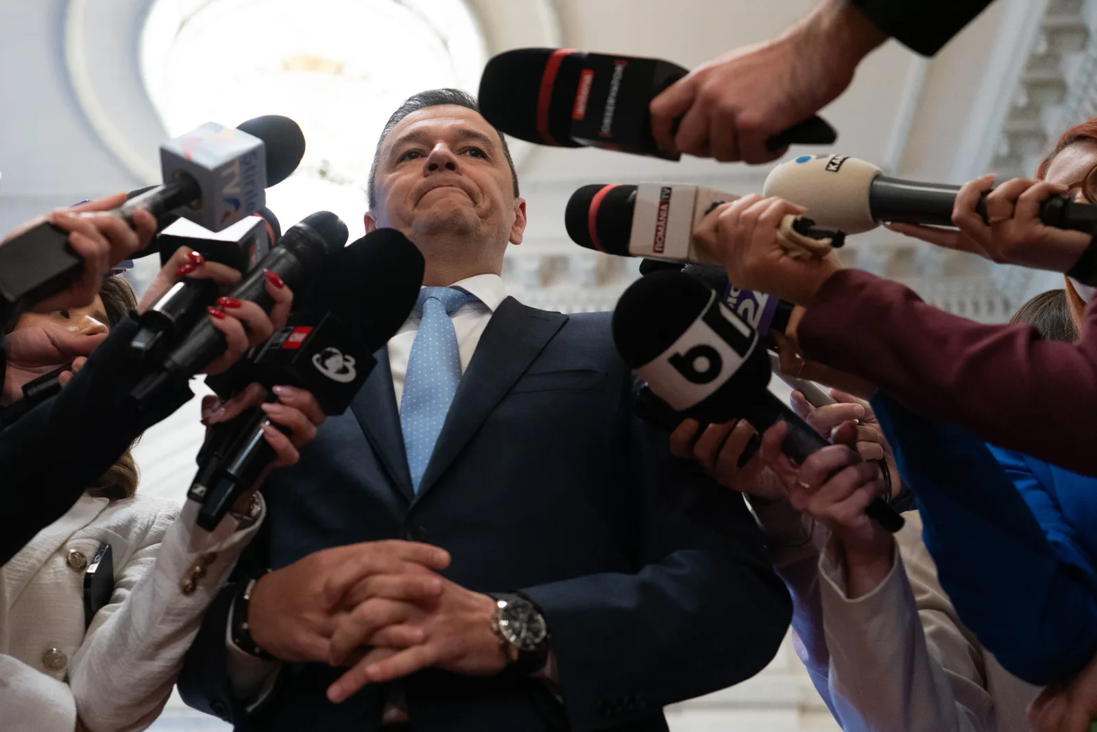 Sorin Grindeanu înconjurat de jurnaliști la o conferință de presă.