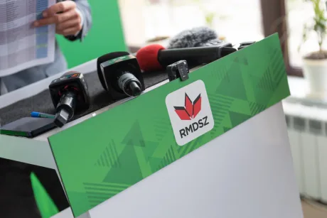 Masa de presă UDMR cu microfoane și logo-ul partidului.