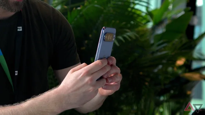 Utilizator care interacționează cu un telefon mobil într-un mediu verde.