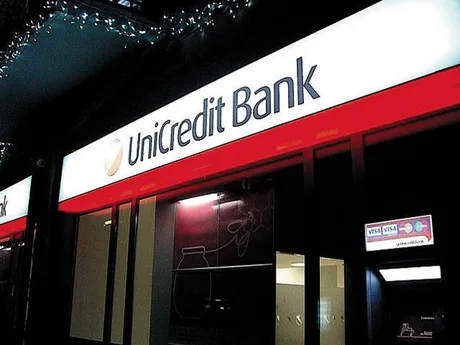 Sucursala UniCredit Bank cu logo și iluminare nocturnă.