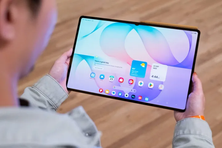 Un utilizator interacționează cu un telefon cu ecran rulabil, explorând funcționalitățile acestuia.