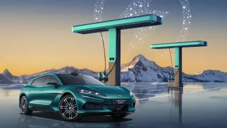 Mașină electrică modernă la o stație de încărcare în peisaj montan.