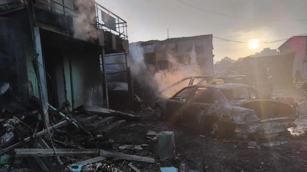 Distrugeri cauzate de atacurile rusești în Ucraina, cu mașini avariate și fum.