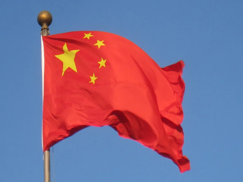 Steagul Chinei fluturând pe un fundal albastru senin.