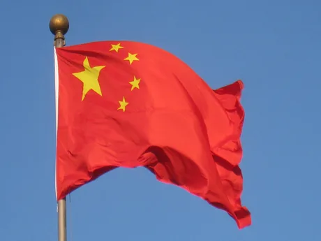 Steagul Chinei fluturând pe un fundal albastru senin.