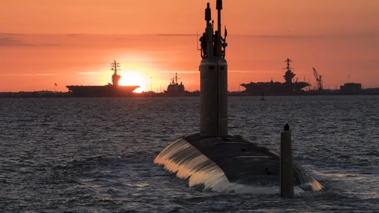 Submarin nuclear navigând la apus, simbol al cooperării internaționale în securitate.