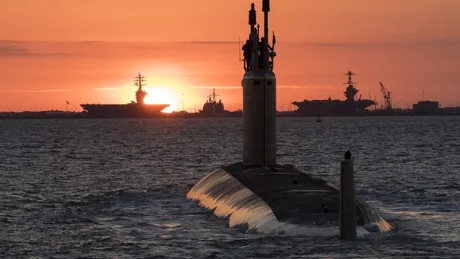 Submarin nuclear navigând la apus, simbol al cooperării internaționale în securitate.
