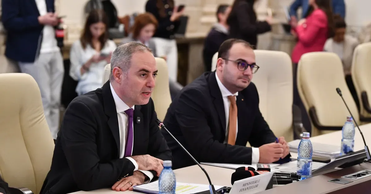 Ministrul Finanțelor discutând despre deficitul bugetar în cadrul unei întâlniri oficiale.