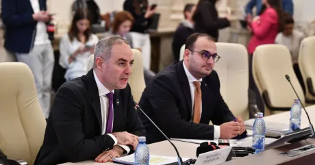 Ministrul Finanțelor discutând despre deficitul bugetar în cadrul unei întâlniri oficiale.