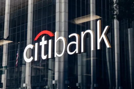 Sucursala Citibank reflectată în clădirea din fundal, simbolizând tensiuni financiare.