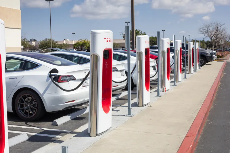 Statii de încărcare pentru mașini electrice Tesla, parcate în rând.
