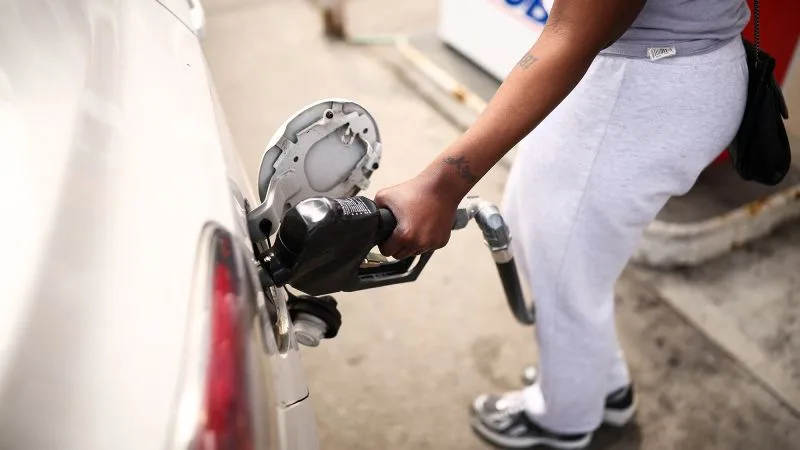 O persoană alimentează o mașină cu benzină la o stație de carburant.