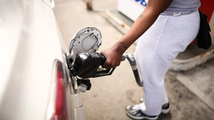 O persoană alimentează o mașină cu benzină la o stație de carburant.