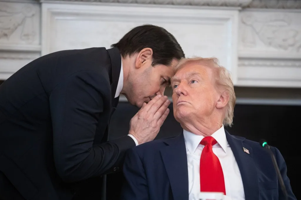 Donald Trump ascultând un consilier în birou.
