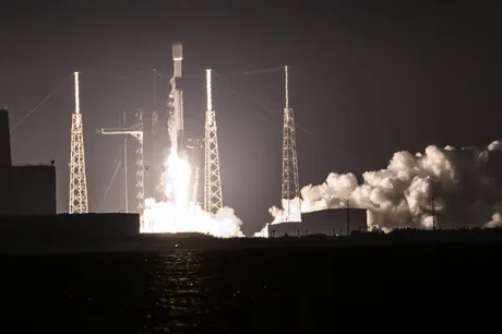 Lansare de rachete SpaceX în noapte, cu flăcări și fum.