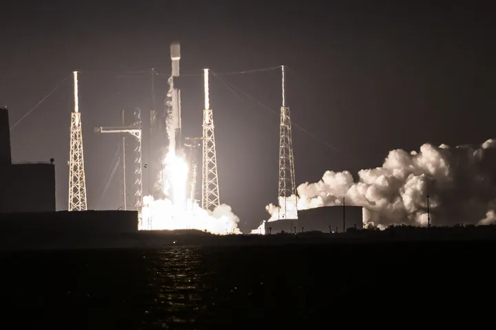 Lansare de rachete SpaceX în noapte, cu flăcări și fum.