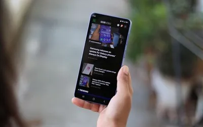 Un utilizator examinează un smartphone Samsung într-un mediu urban.
