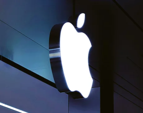 Logo-ul Apple iluminat pe un fundal întunecat.