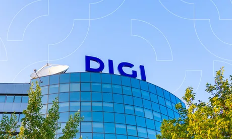 Clădire modernă cu sigla Digi pe un fundal albastru senin.