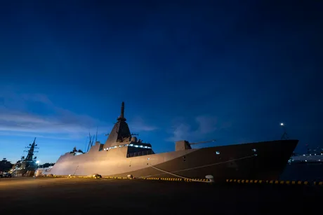 Nave de război ancorate în port, sub cerul înstelat al nopții.