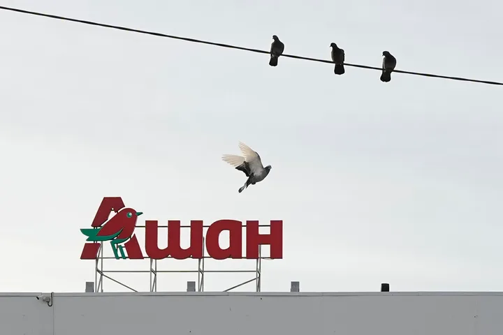 Păsări pe fire electrice lângă un magazin Auchan în Rusia.