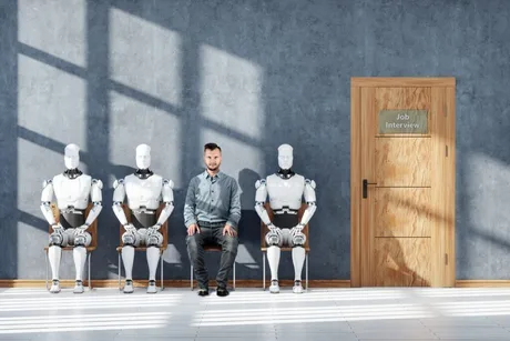 Un bărbat așezat între roboți, așteptând interviul de angajare.