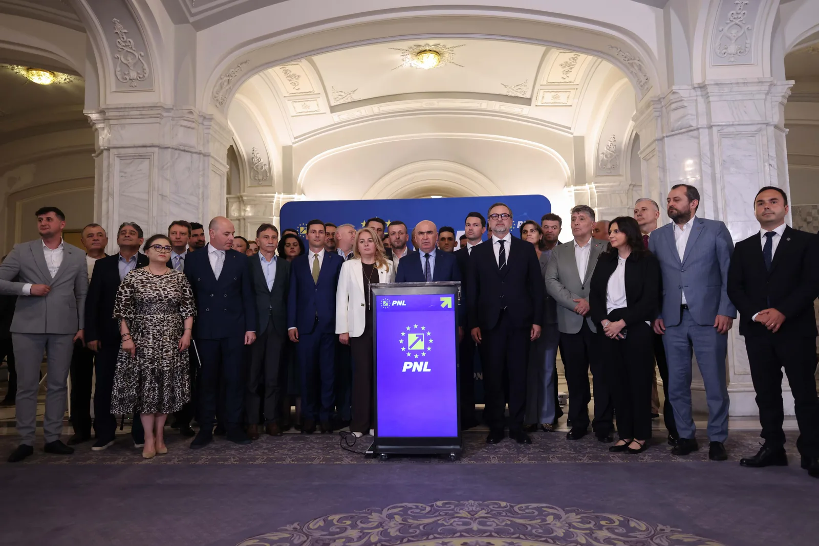 Reuniune a membrilor PNL în fața unui banner al partidului.