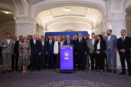 Reuniune a membrilor PNL în fața unui banner al partidului.