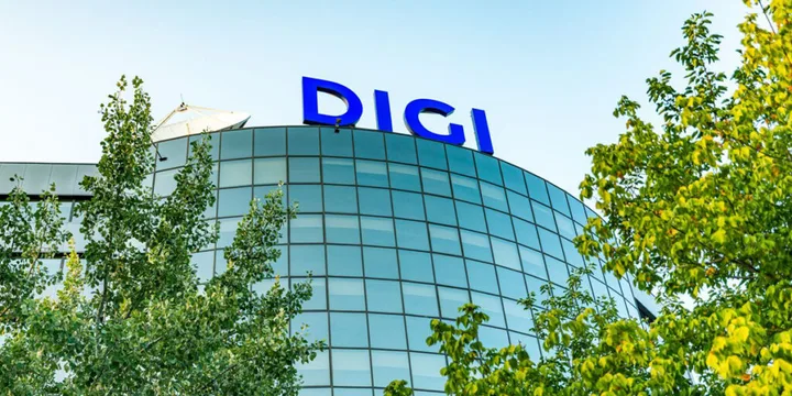 Sediul Digi Communications înconjurat de copaci verzi.