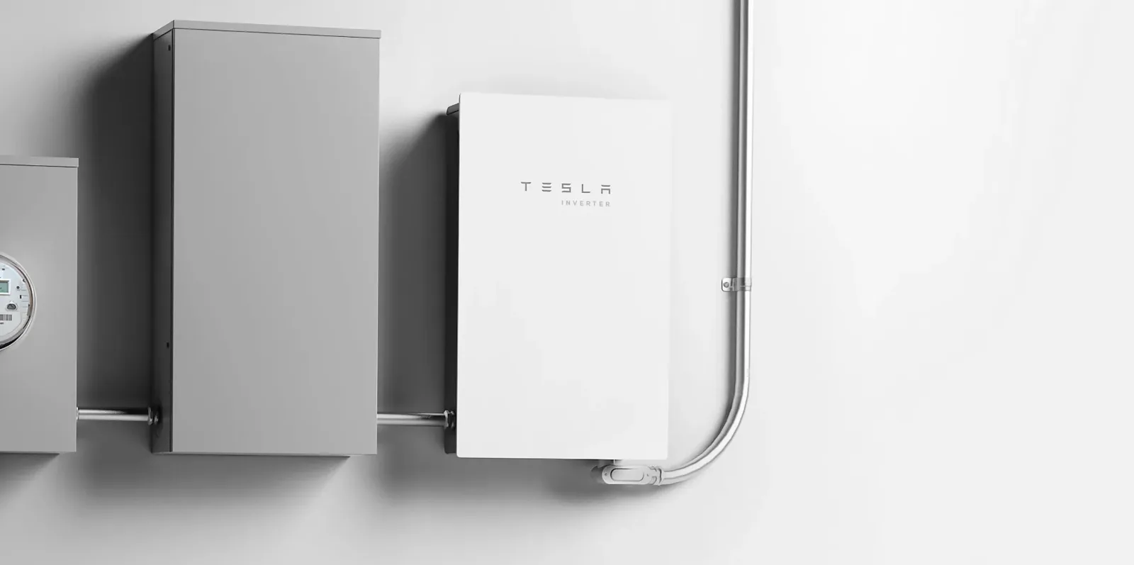 Invertoare solare Tesla instalate pe un perete, cu cabluri conectate.