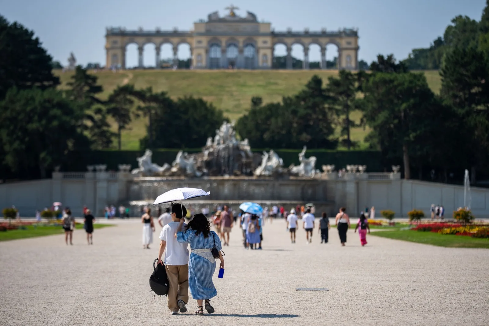 Oameni plimbându-se într-un parc din Viena pe vreme caniculară.