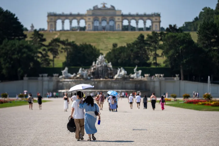 Oameni plimbându-se într-un parc din Viena pe vreme caniculară.