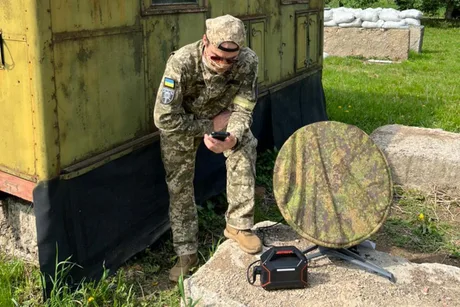 Soldat rus folosind un dispozitiv de comunicație în condiții dificile.