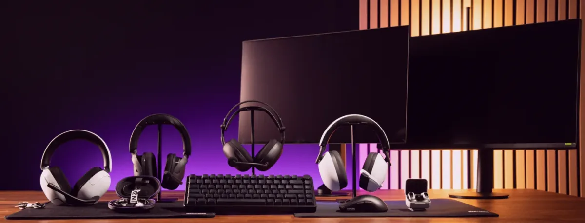 Căști INZONE H6 Air alături de un monitor și un keyboard pe birou.