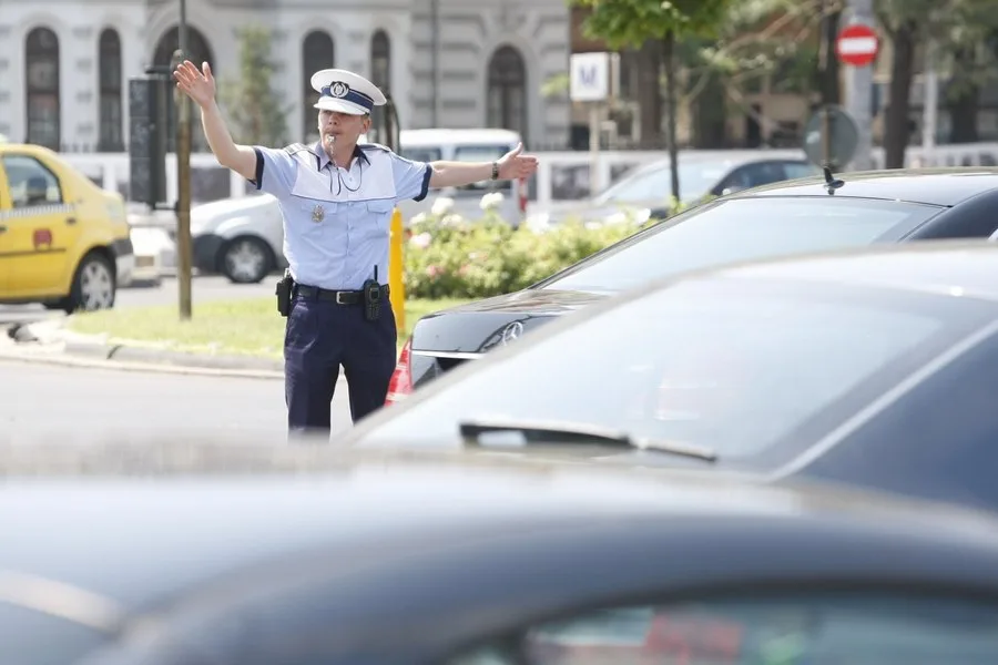 Polițist dirijând traficul într-o intersecție aglomerată.