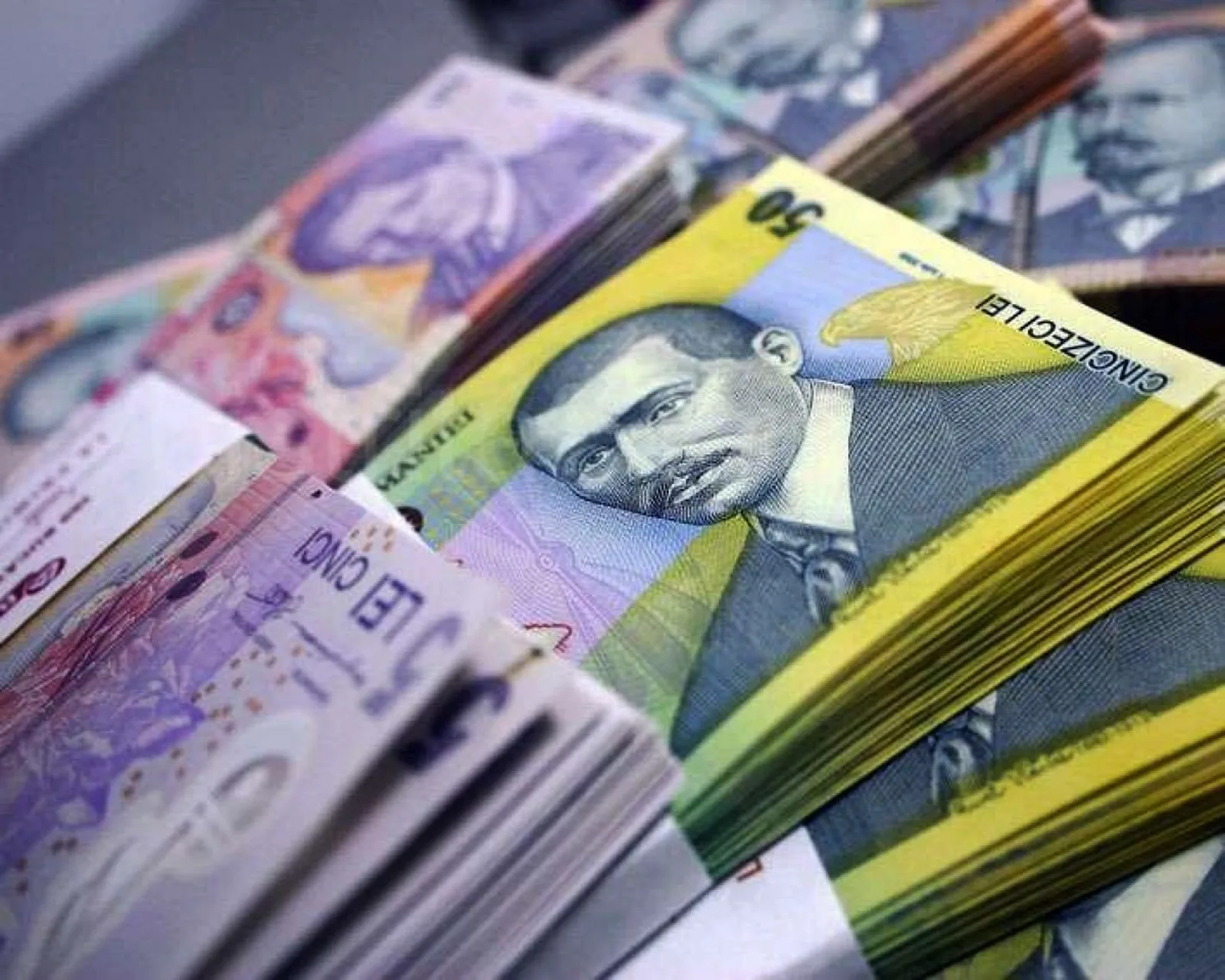 Bancnote românești aranjate pe o masă, simbolizând scăderea dobânzilor.