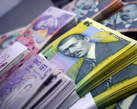 Bancnote românești aranjate pe o masă, simbolizând scăderea dobânzilor.