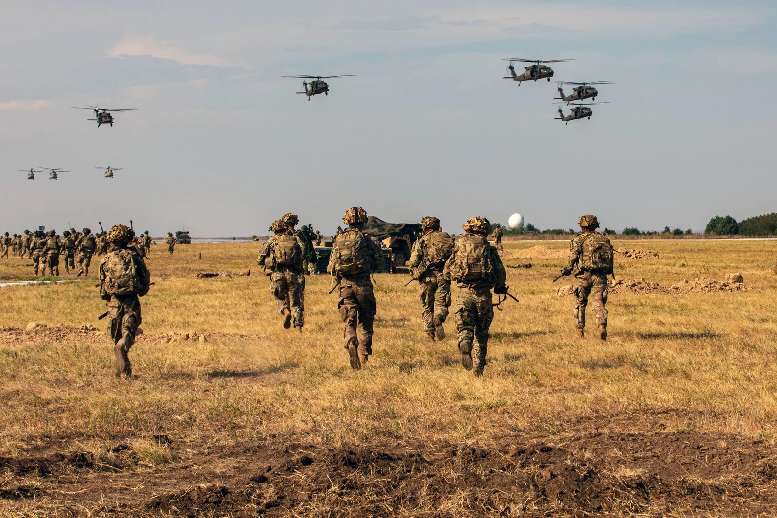 Soldați americani în exerciții militare pe un câmp deschis.