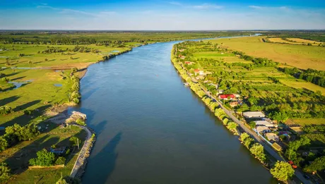 Canalul Sulina, cu peisaje verzi și apă liniștită, în așteptarea navelor.