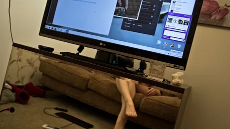 O persoană participând la o sesiune de videochat pe un monitor mare.