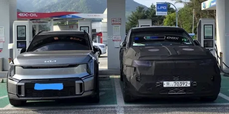 Compararea dimensiunilor dintre SUV-ul electric Genesis GV90 și Kia EV9 la stația de încărcare.