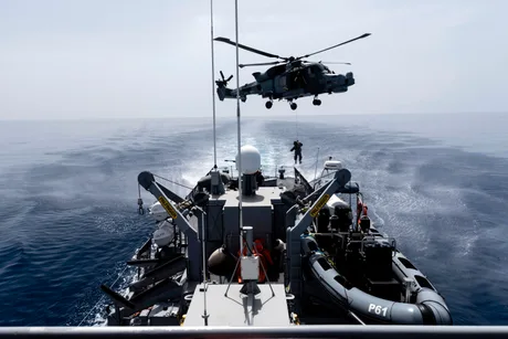 Operațiune de salvare în desfășurare pe mare, cu elicoptere și nave implicate.