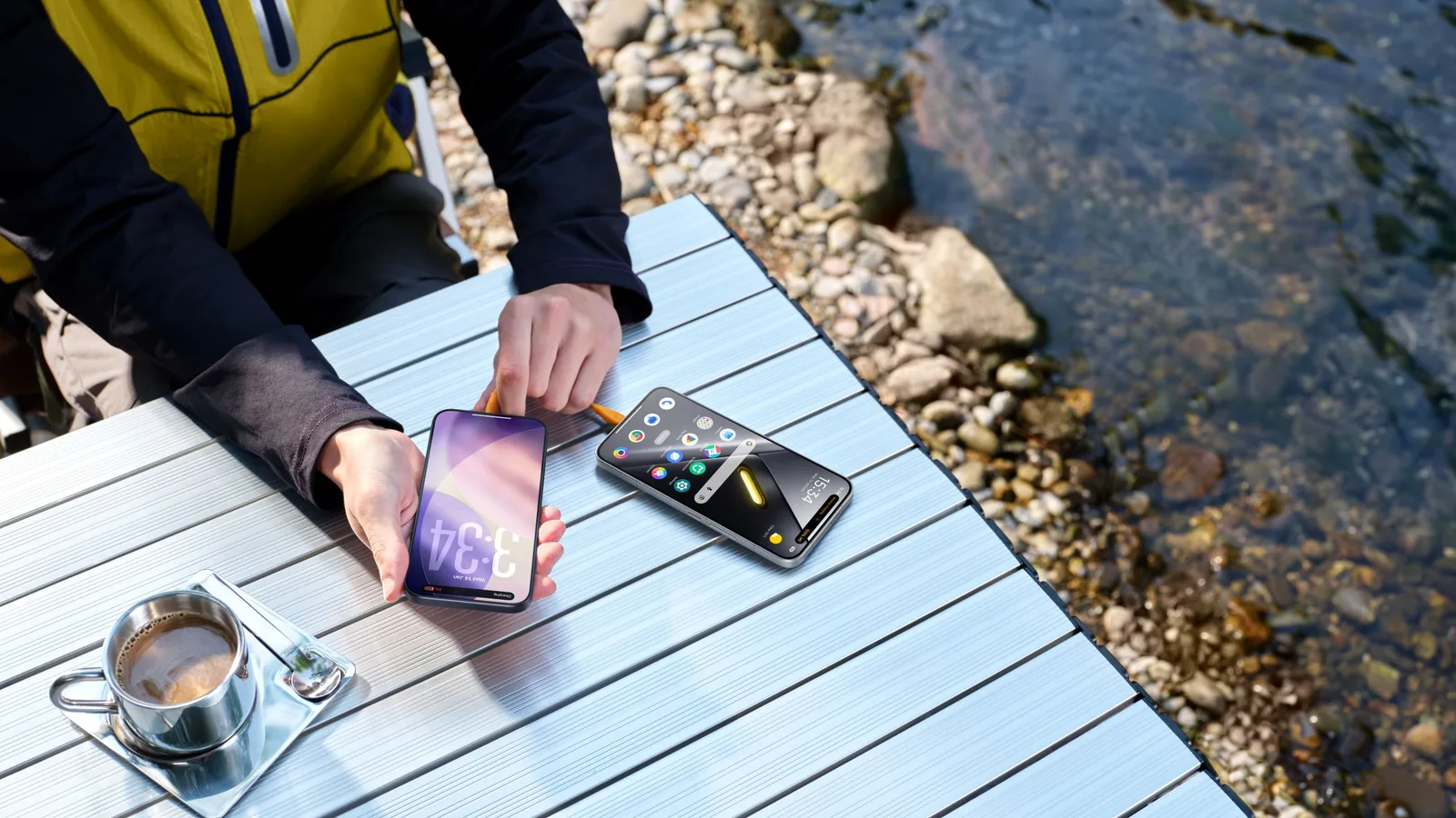 Utilizator interacționând cu smartphone-uri pe o masă lângă apă.