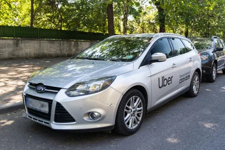 Mașină Uber parcată într-un oraș din România, pregătită pentru utilizatori.