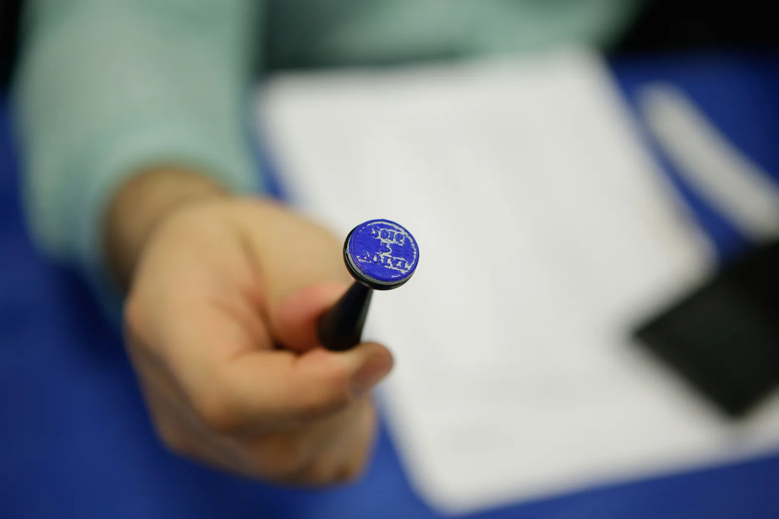 Un vot simbolic cu ștampila pe un pix, evidențiind participarea la alegeri.