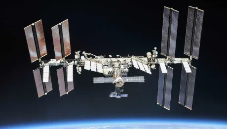 Stația Spațială Internațională văzută de la distanță, cu panouri solare extinse.
